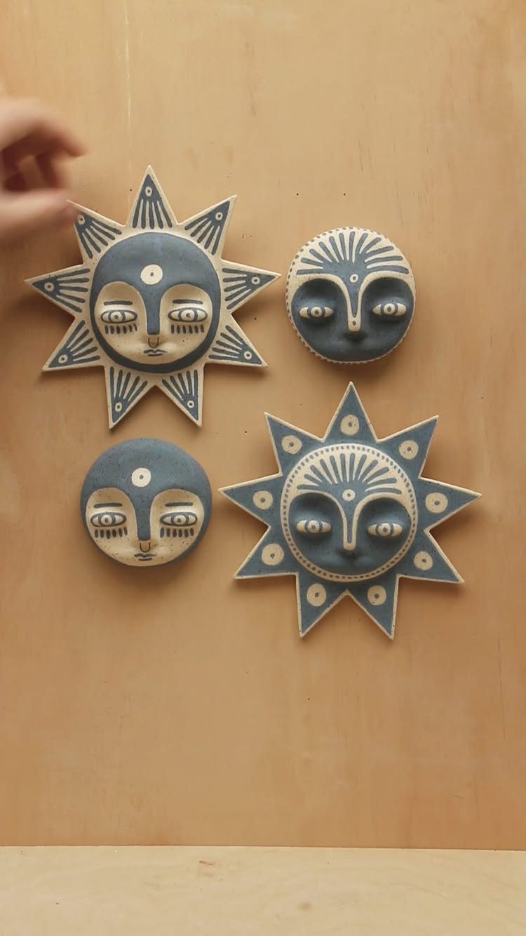30 DIY Clay Crafts to Make with Air-Dry Clay for Home Decor 30 Four grey and cream clay sun and moon face plaques on a wooden wall.