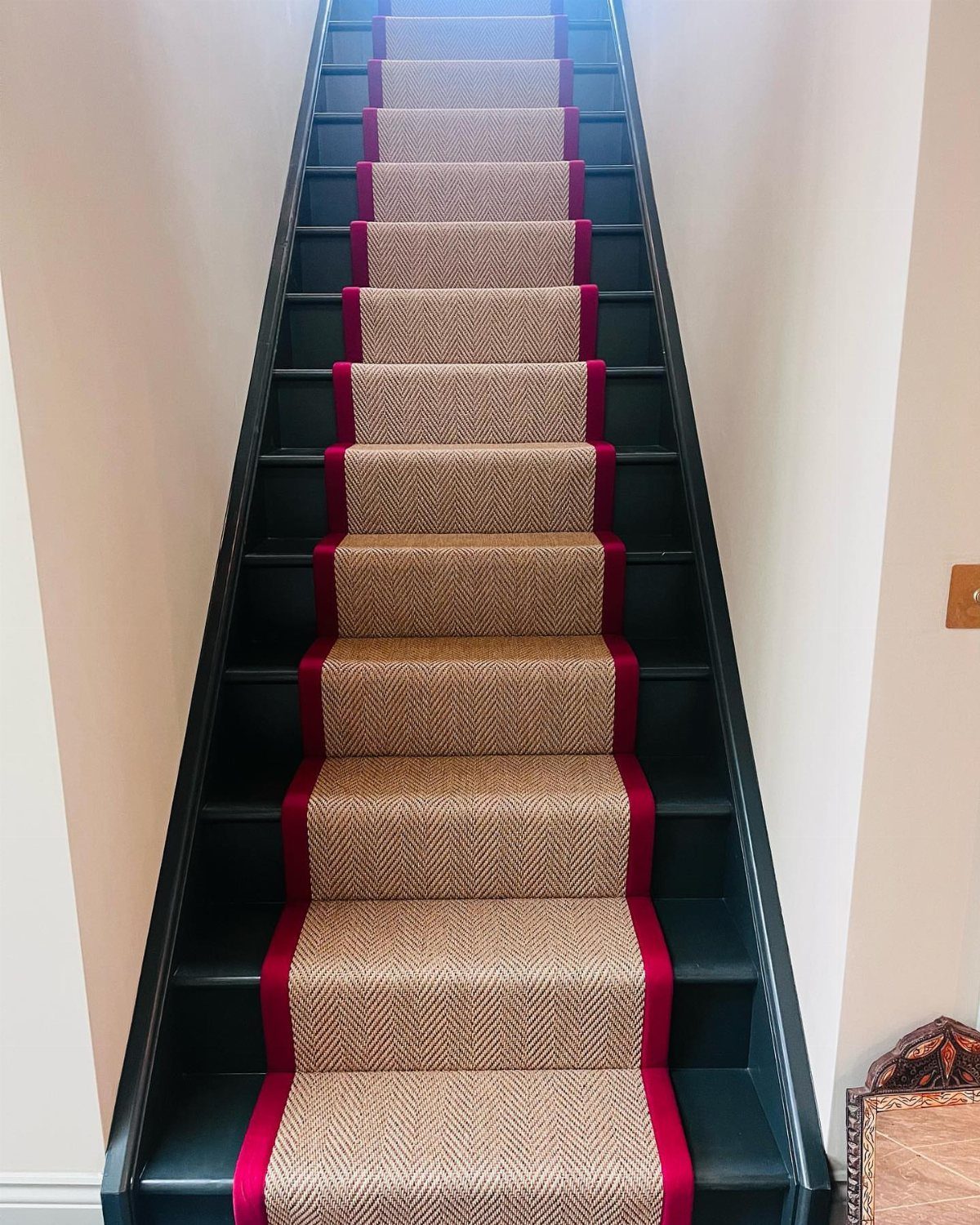Stairs with Carpet: 23 Styles from Runners to Bold Patterns 13 Beige textured carpet runner with red borders on black wooden stairs