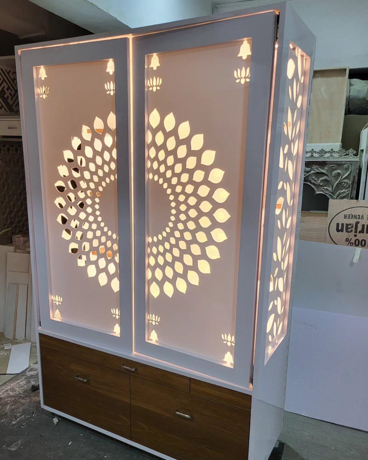 34 Puja Unit Design Modern Ideas for Your Home in 2026 16 White wooden mandir with backlit circular jaali patterns and dark brown storage drawers.