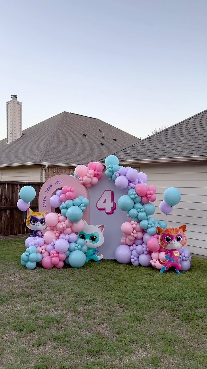 Pink, purple, and blue balloon garlands framing a large number four birthday backdrop.