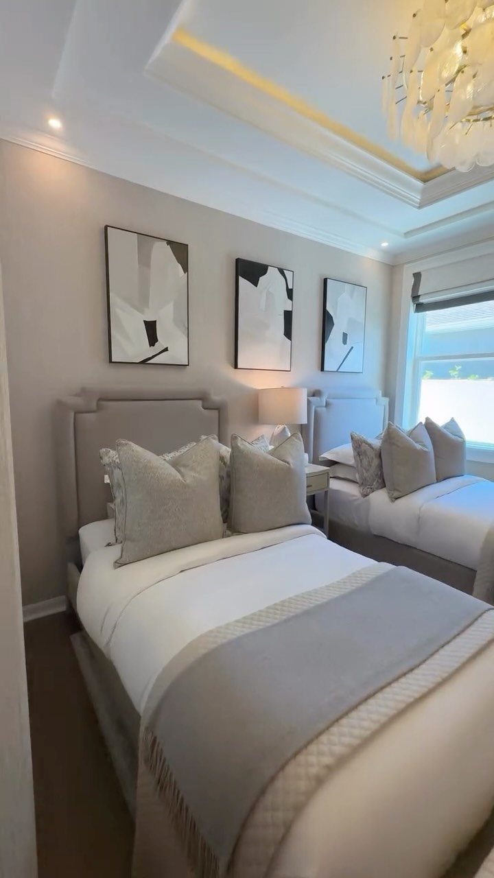 22 Bedroom Empty Wall Ideas, from Gallery Walls to Plaster 20 Two twin beds with grey headboards and abstract art on a grey wall.