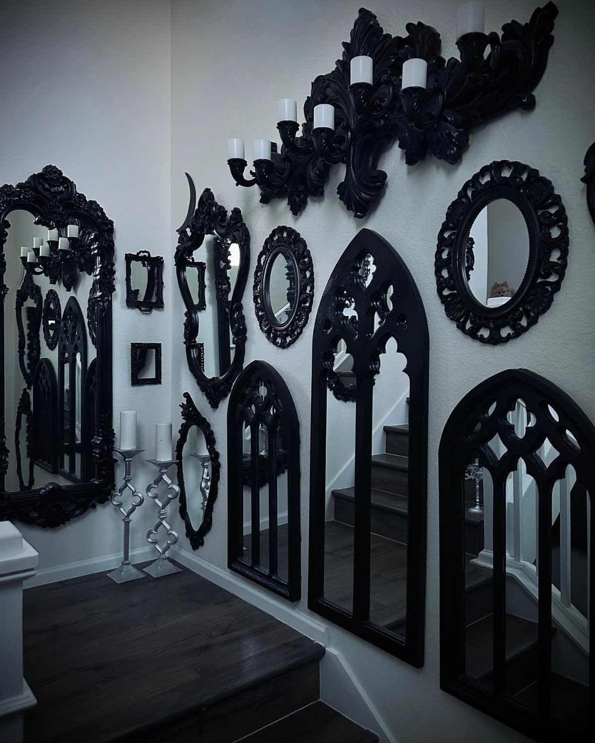 Mirror Wall Art: 25 Ideas from Sunburst to Floor Mirrors 3 Ornate black mirrors and a matching wall sconce on a white hallway wall.