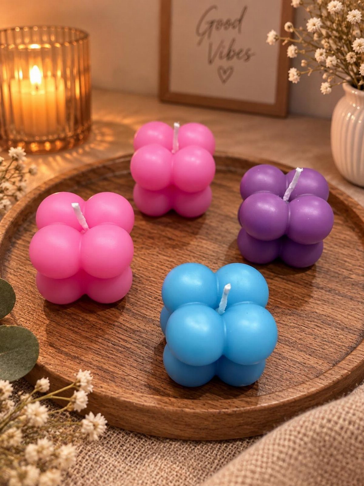 23 Cool House Items for Walls, Shelves, Desks, and Baths 11 Colorful bubble candles on a wooden tray with a lit candle and flowers.