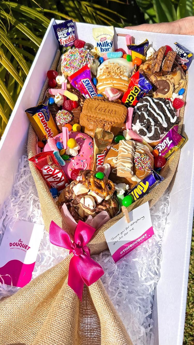 Candy bouquet wrapped in burlap with a pink ribbon and assorted chocolates.