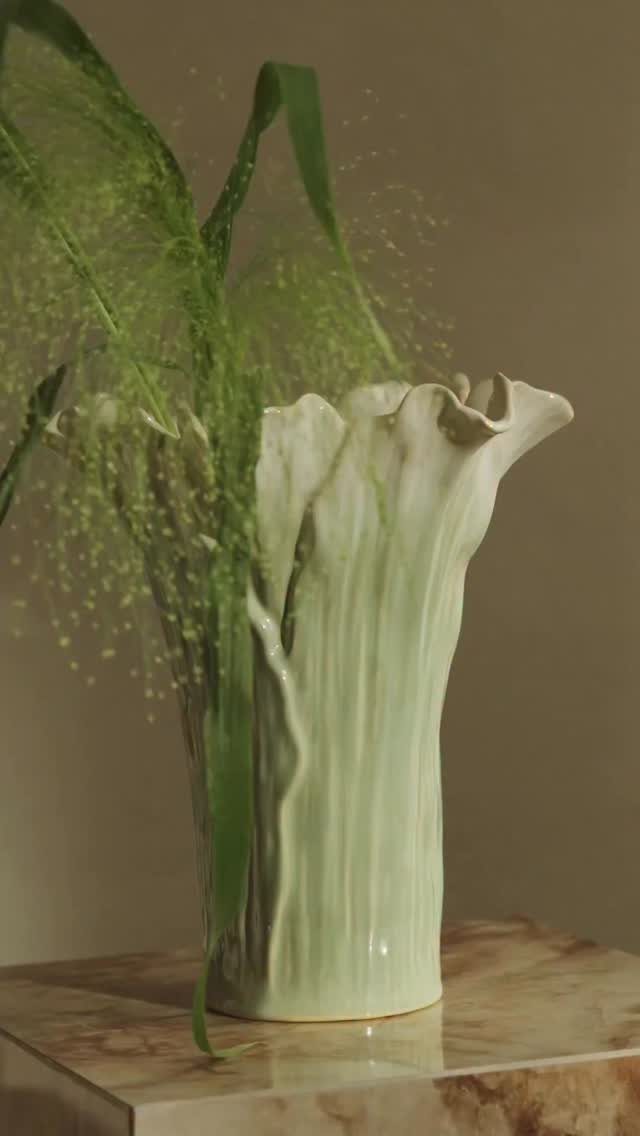 40 Home Decor Item Ideas, From Candle Holders to Sculptures 1 Sculptural light green ceramic vase with green foliage on a marble surface.