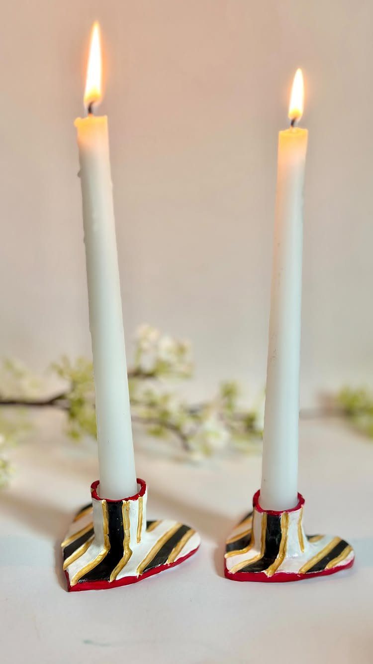 30 DIY Clay Crafts to Make with Air-Dry Clay for Home Decor 10 Two lit white taper candles in handmade boot-shaped clay holders with colorful stripes.