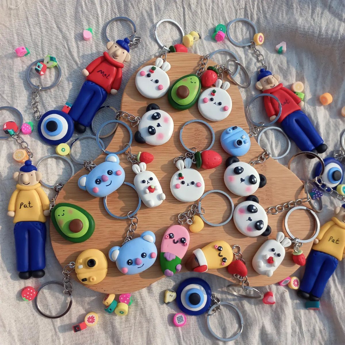 30 DIY Clay Crafts to Make with Air-Dry Clay for Home Decor 21 Colorful polymer clay keychains in various shapes and characters on a wooden board.