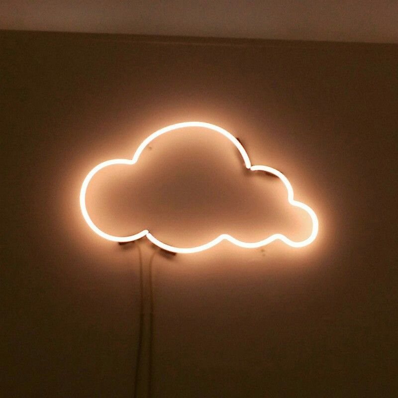 White neon cloud light glowing against a dark, neutral wall.