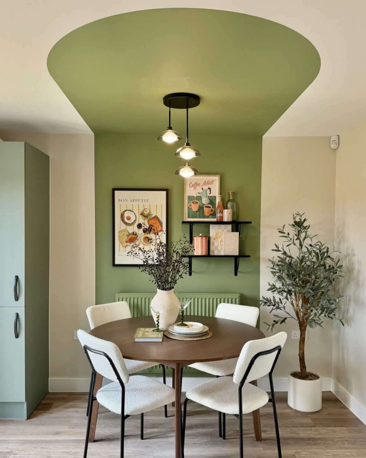 Dining room with sage green color-blocked paint on the ceiling and accent wall.