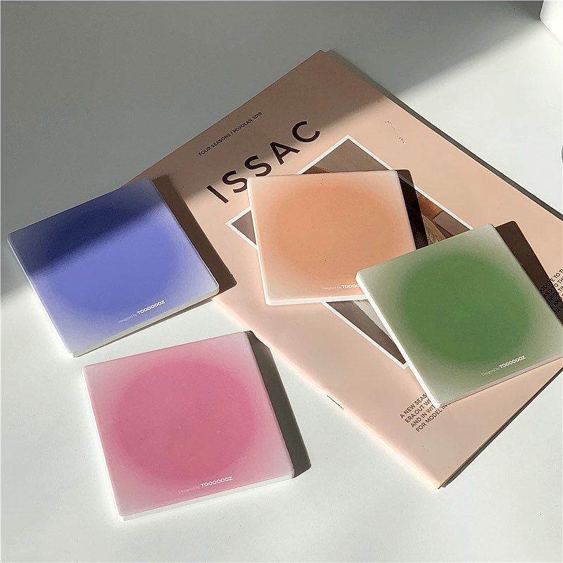 23 Cool House Items for Walls, Shelves, Desks, and Baths 16 Four colorful frosted glass coasters on a white surface and a magazine.