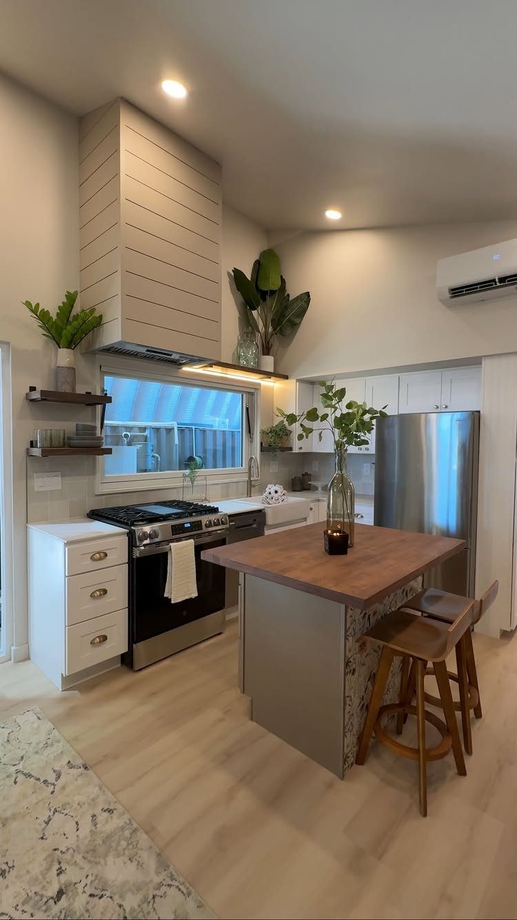 Tiny House Layout Ideas: 34 Kitchens, Lofts, Decks, Porches 26 Modern tiny house kitchen with a wooden island, stainless steel appliances, and light flooring.