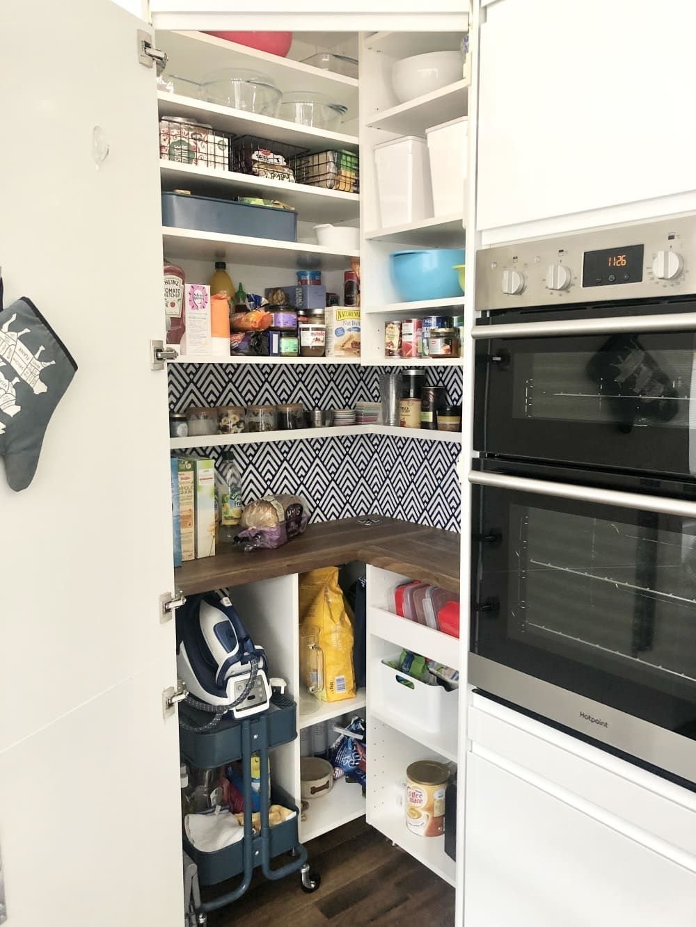 24 Corner Shelves IKEA Ideas for Kitchens, TVs and Plants 7 Open white corner kitchen cabinet with chevron wallpaper and organized pantry shelves.