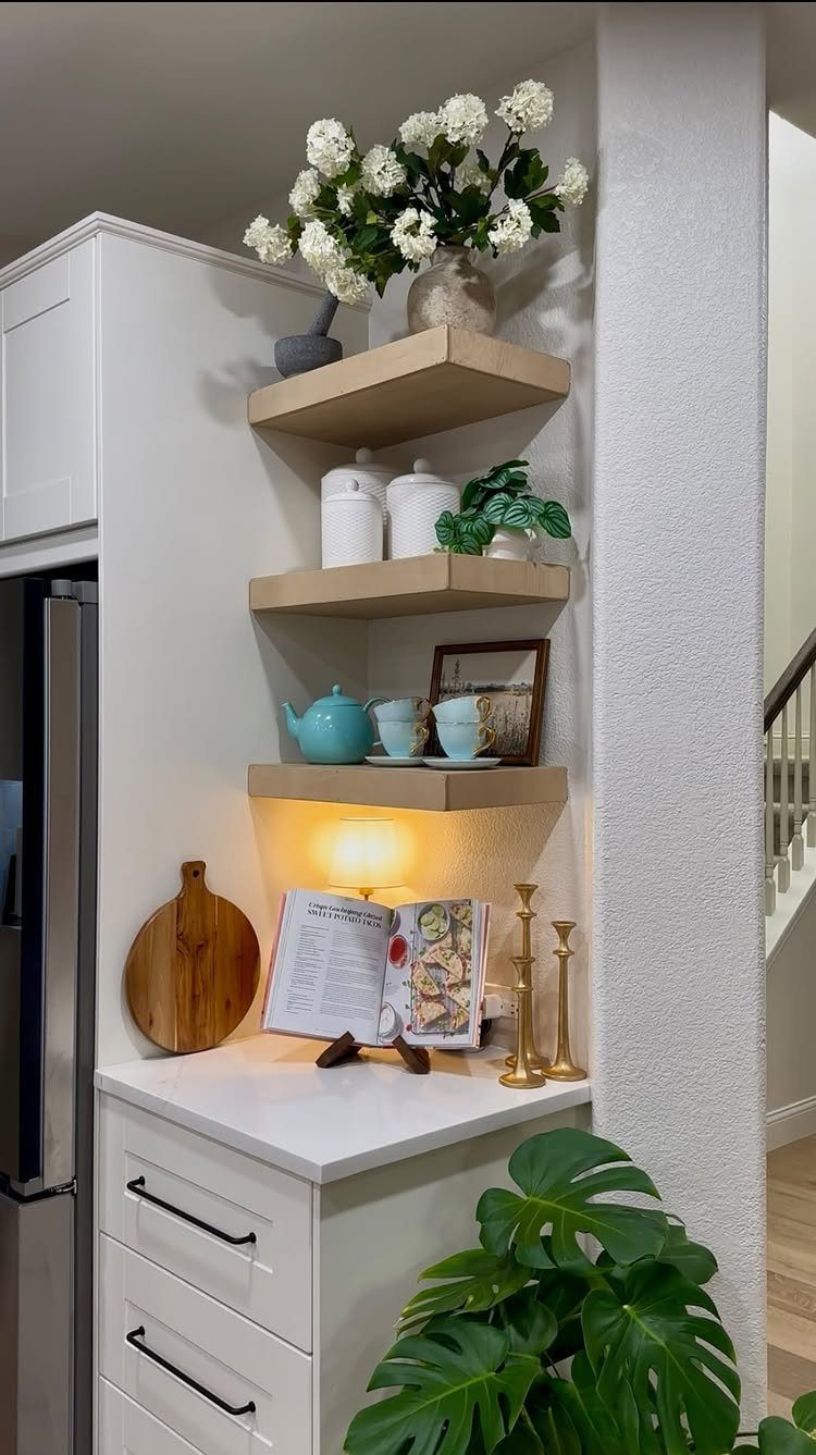 24 Corner Shelves IKEA Ideas for Kitchens, TVs and Plants 22 Wooden corner shelves in a kitchen holding white flowers, canisters, and a blue teapot.