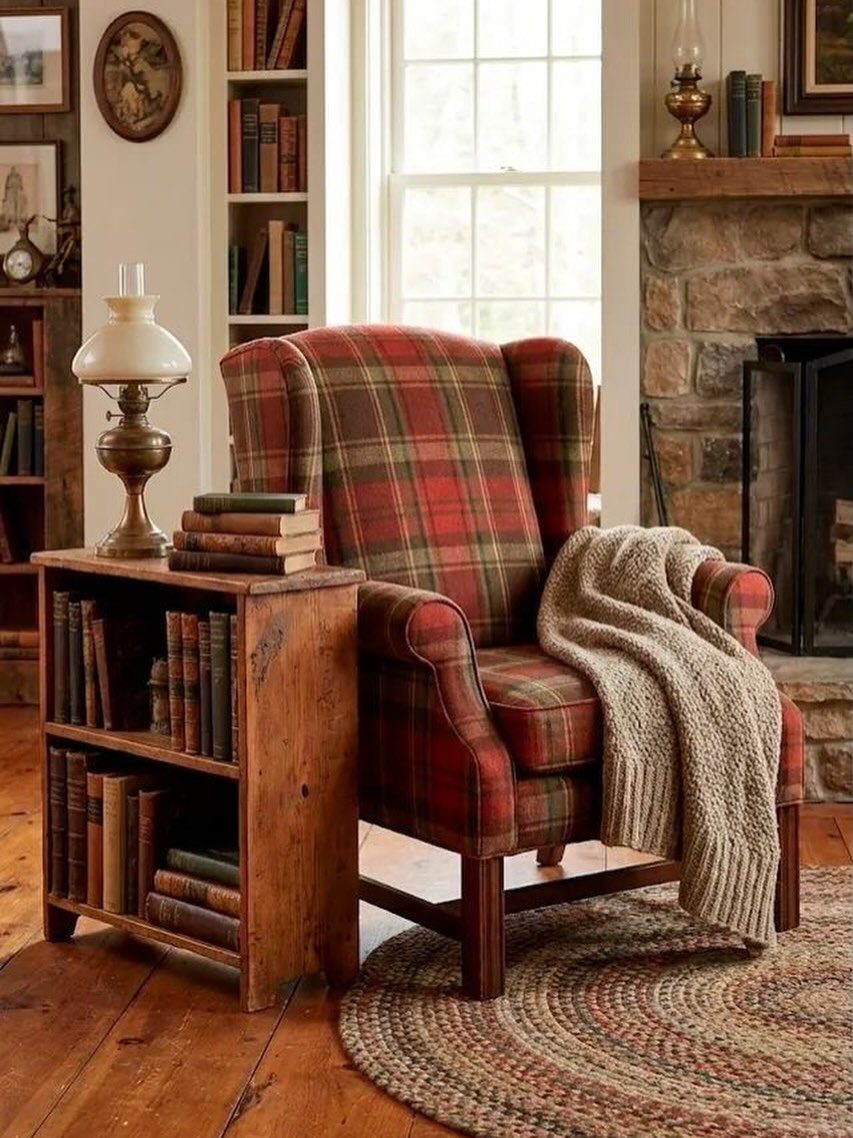 Red plaid wingback chair with a throw blanket next to a small wooden bookshelf.