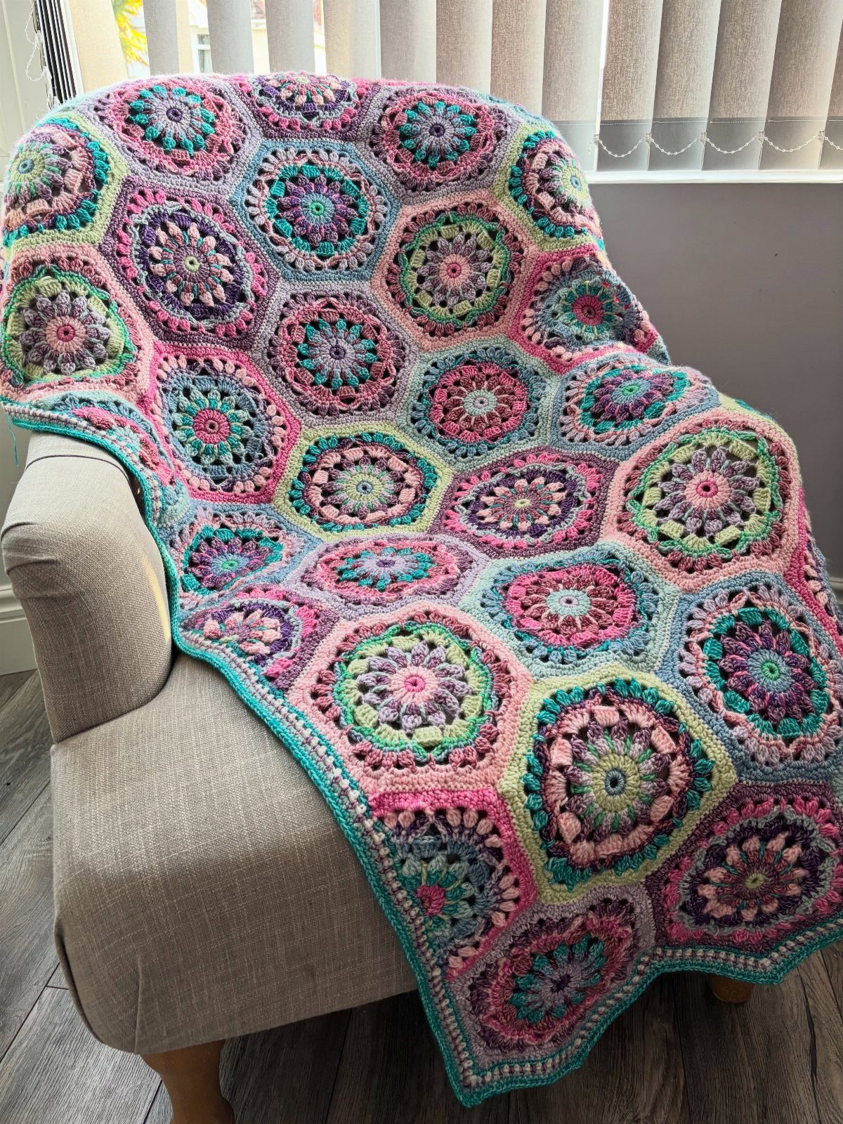 23 Cool House Items for Walls, Shelves, Desks, and Baths 23 Colorful crocheted hexagonal blanket draped over a beige fabric armchair.