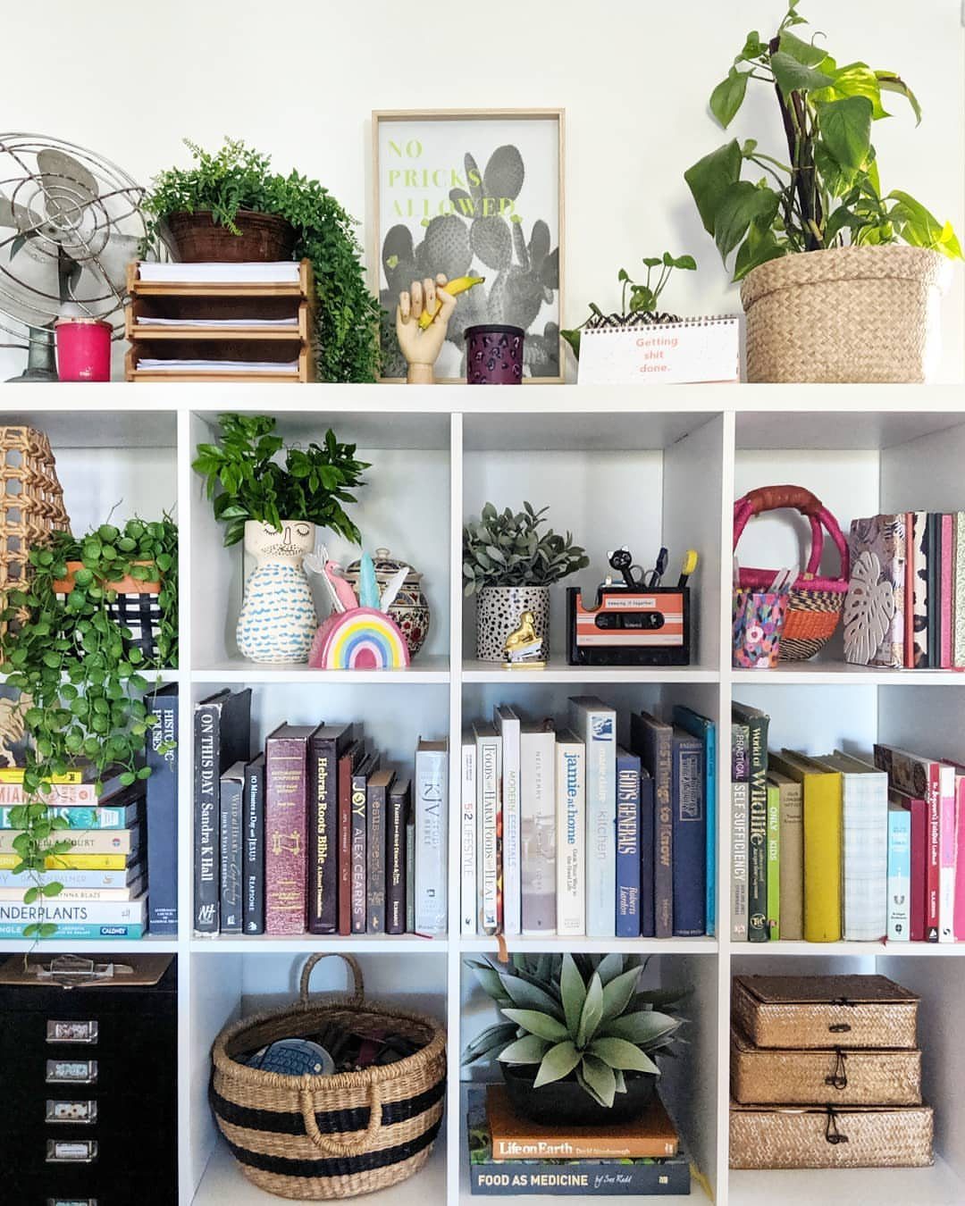 12 Ideas for Book Storage From Floating Shelves to Side Tables 8 White modular cube shelving unit containing books, plants, and woven storage baskets.