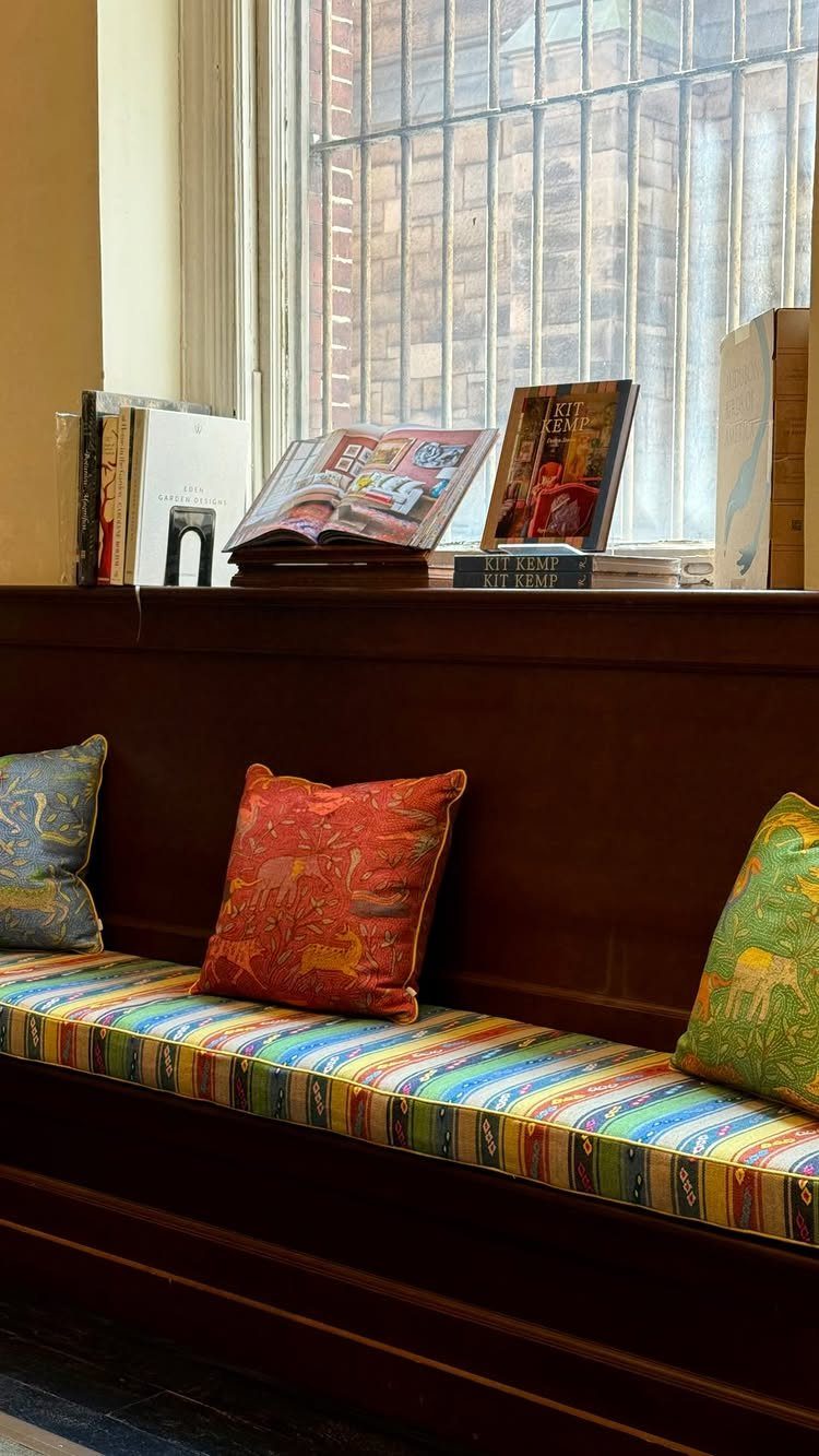 Colorful striped window seat with red, blue, and green decorative throw pillows.