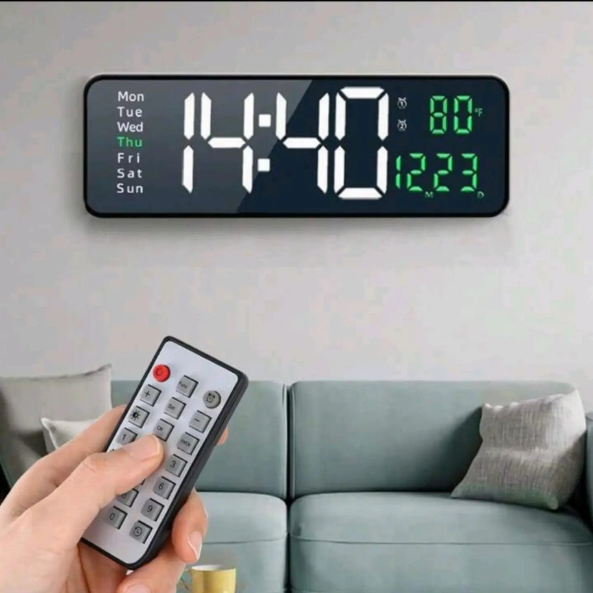 23 Cool House Items for Walls, Shelves, Desks, and Baths 17 Digital wall clock displaying time and temperature with a hand holding a remote.