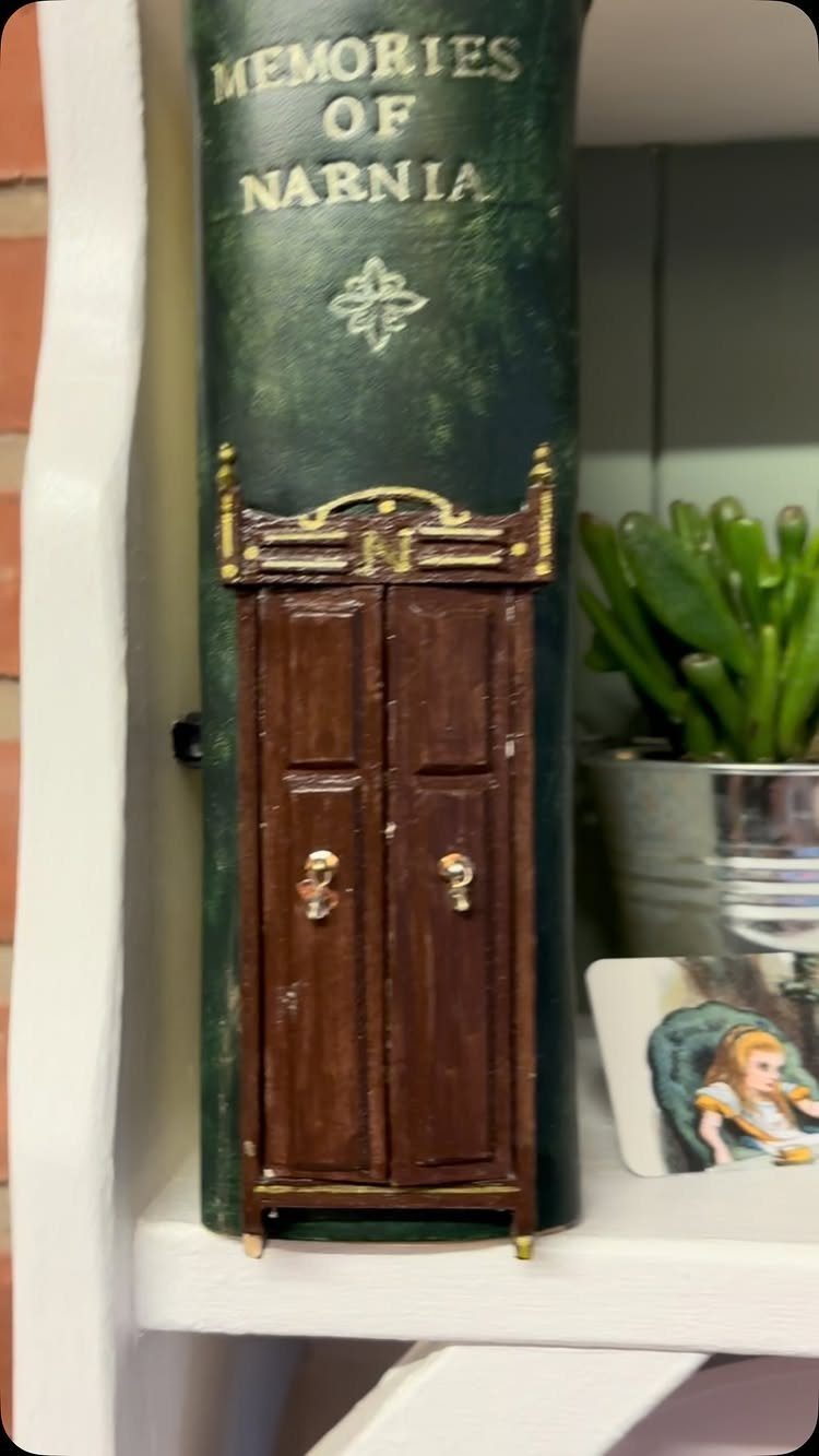 Green book titled Memories of Narnia with miniature brown wooden doors attached.