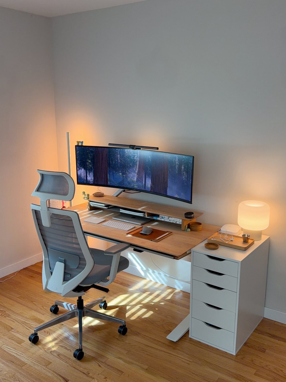 13 Double Monitor Desk Setup Aesthetic Ideas That Work 8 Double curved monitor desk setup with ergonomic chair and warm ambient lighting.