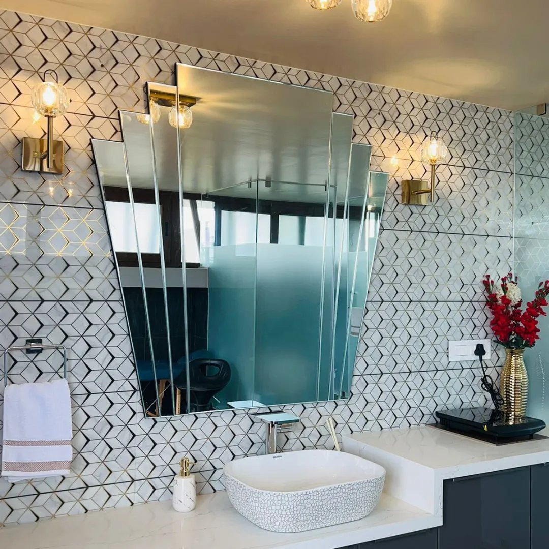 Mirror Wall Art: 25 Ideas from Sunburst to Floor Mirrors 22 Geometric multi-faceted wall mirror above a white vessel sink in a tiled bathroom.