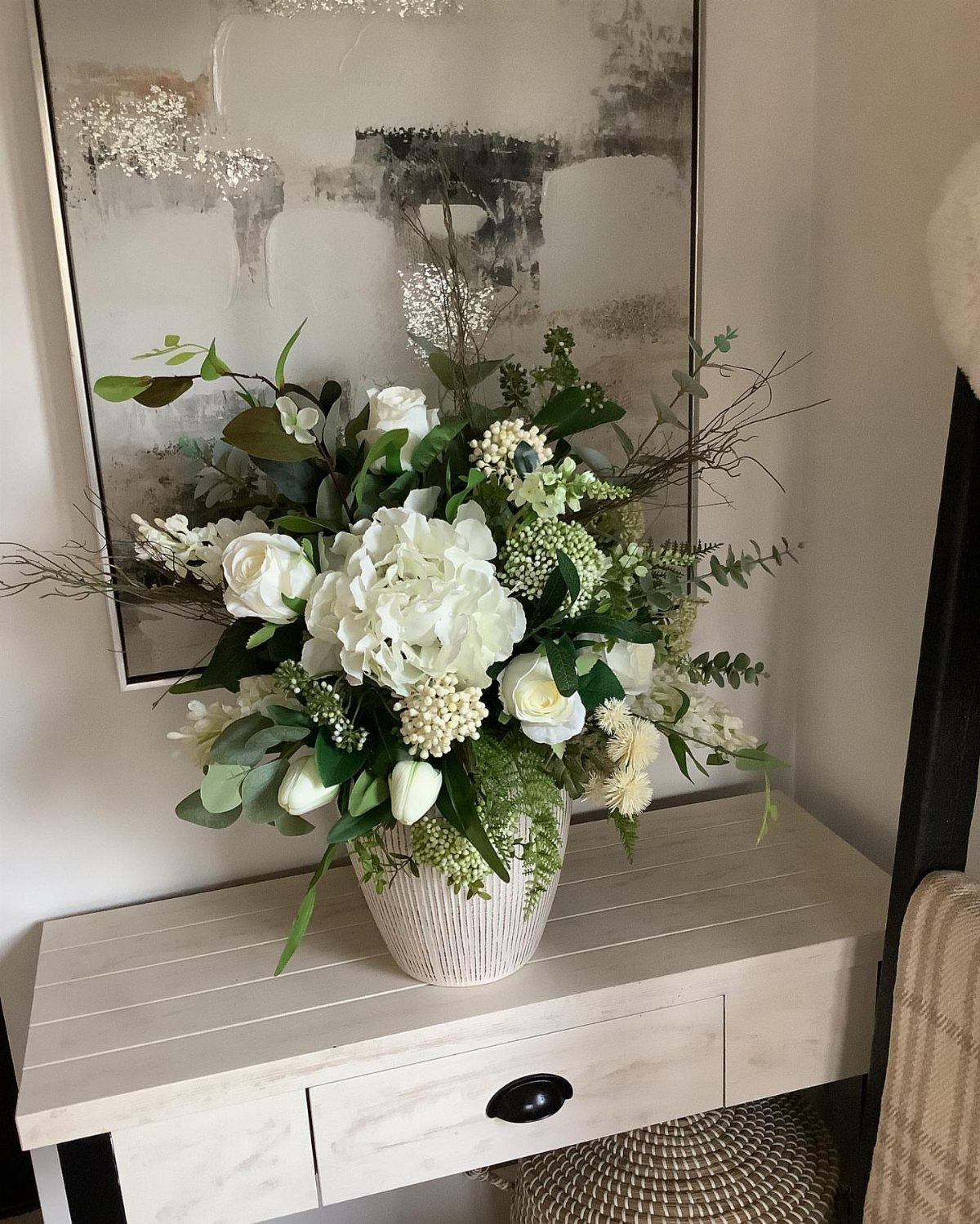 34 Large Floral Arrangement Ideas for Tables, Trays and Vases 13 White floral arrangement with eucalyptus in a white ribbed vase on a wooden table.