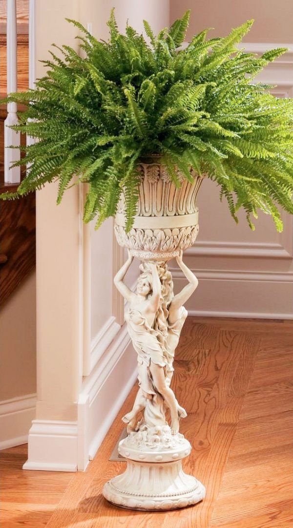 38 Flower Pot on Stand Ideas, from Iron Frames to Pedestals 36 White sculpted pedestal with a female figure holding an urn with a green fern.