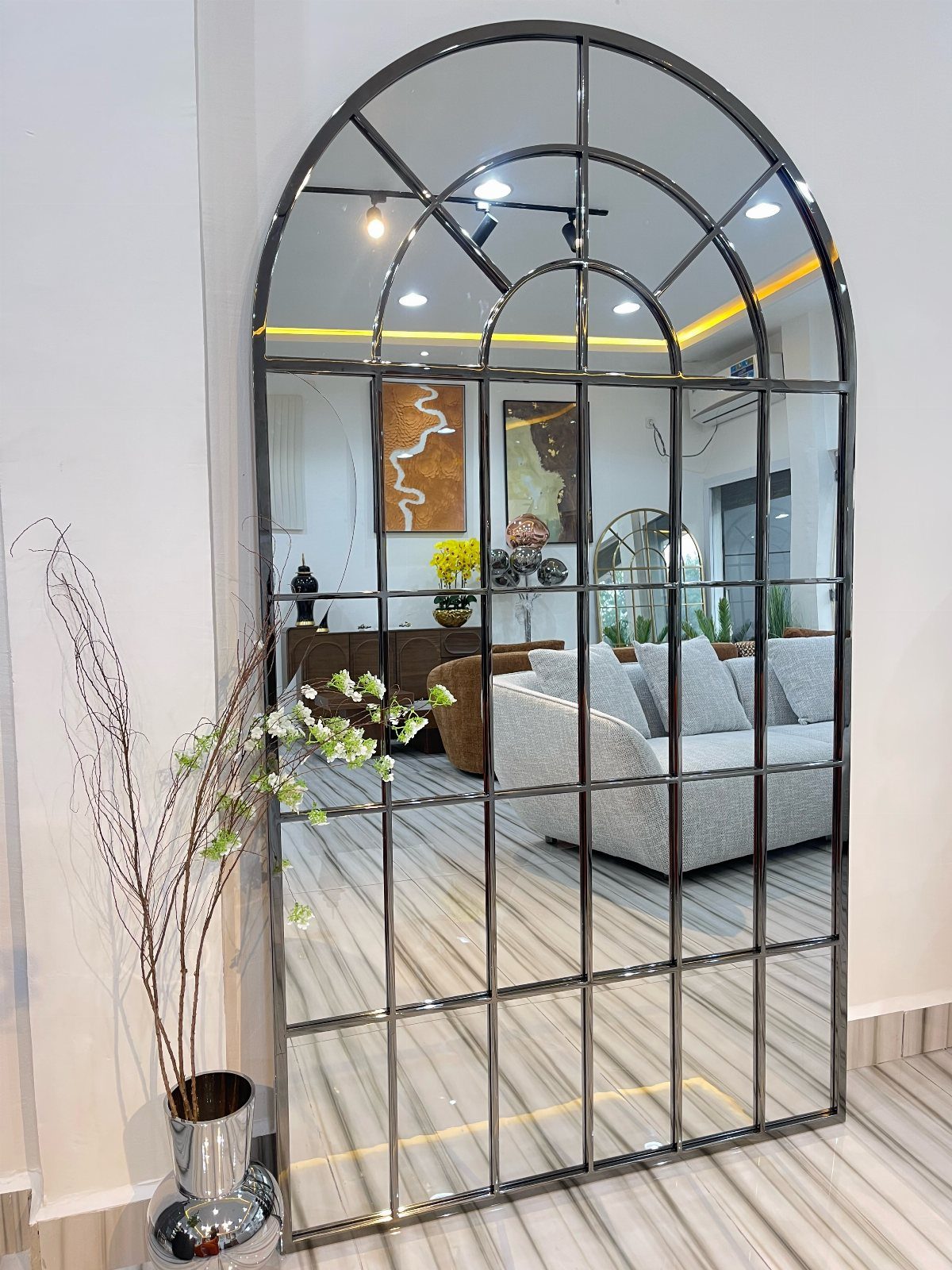 Mirror Wall Art: 25 Ideas from Sunburst to Floor Mirrors 15 Arched floor mirror with black grid frame leaning against a white wall.