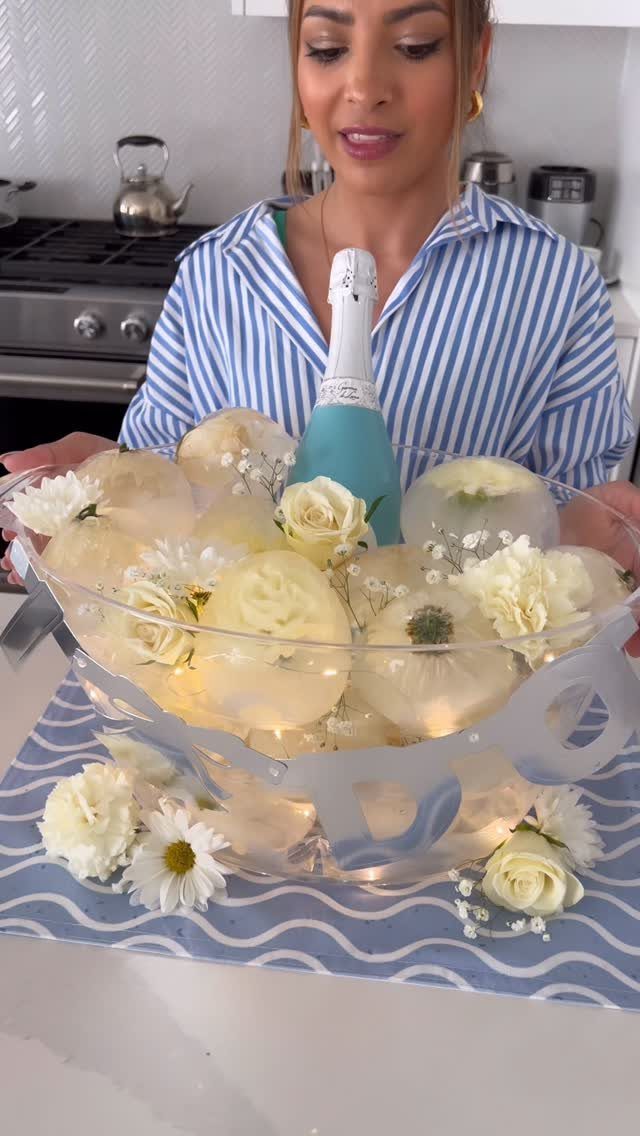 34 Large Floral Arrangement Ideas for Tables, Trays and Vases 32 Large floral arrangement of white roses and daisies surrounding a blue champagne bottle.