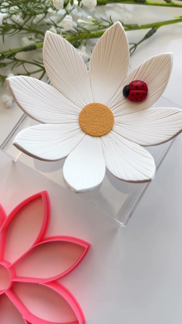 30 DIY Clay Crafts to Make with Air-Dry Clay for Home Decor 6 White daisy-shaped clay dish with a ladybug and a pink flower cookie cutter.