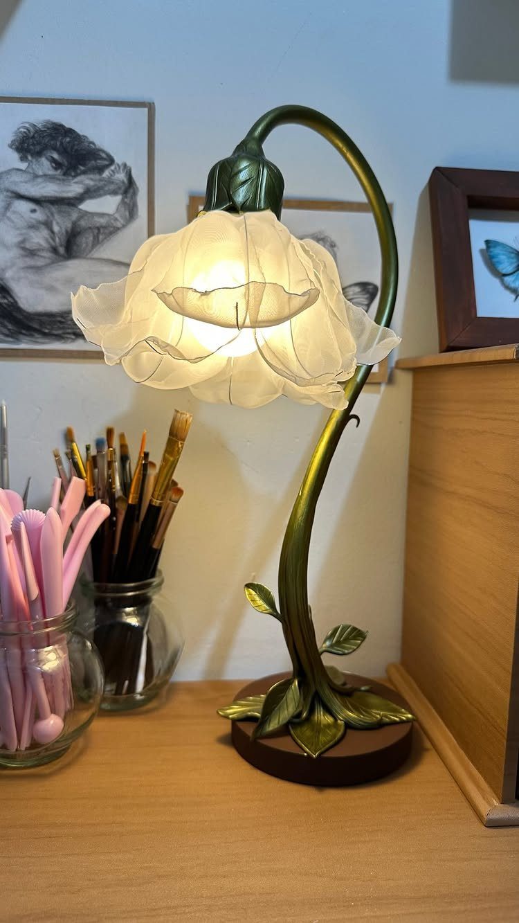 Make Table Lamp Ideas: 14 Designs in Wood, Glass and Ceramic 12 Flower-shaped table lamp with a glowing white shade and curved green stem.