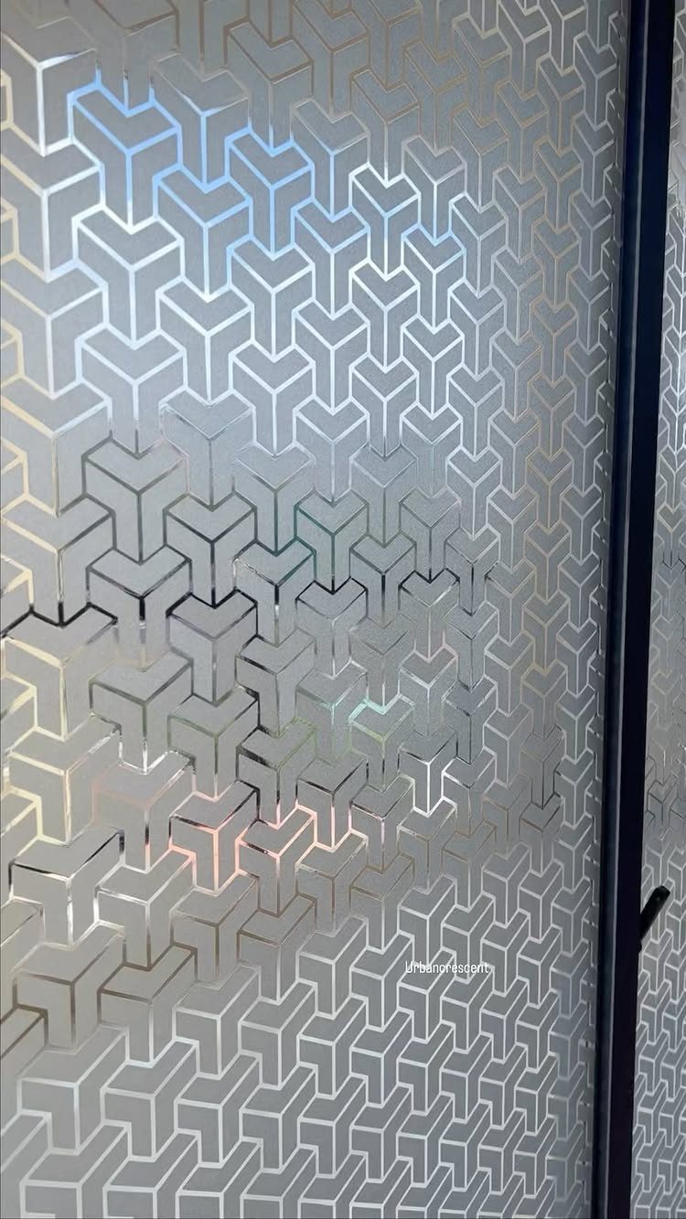 Frosted film with a geometric cube pattern applied to a glass door surface.