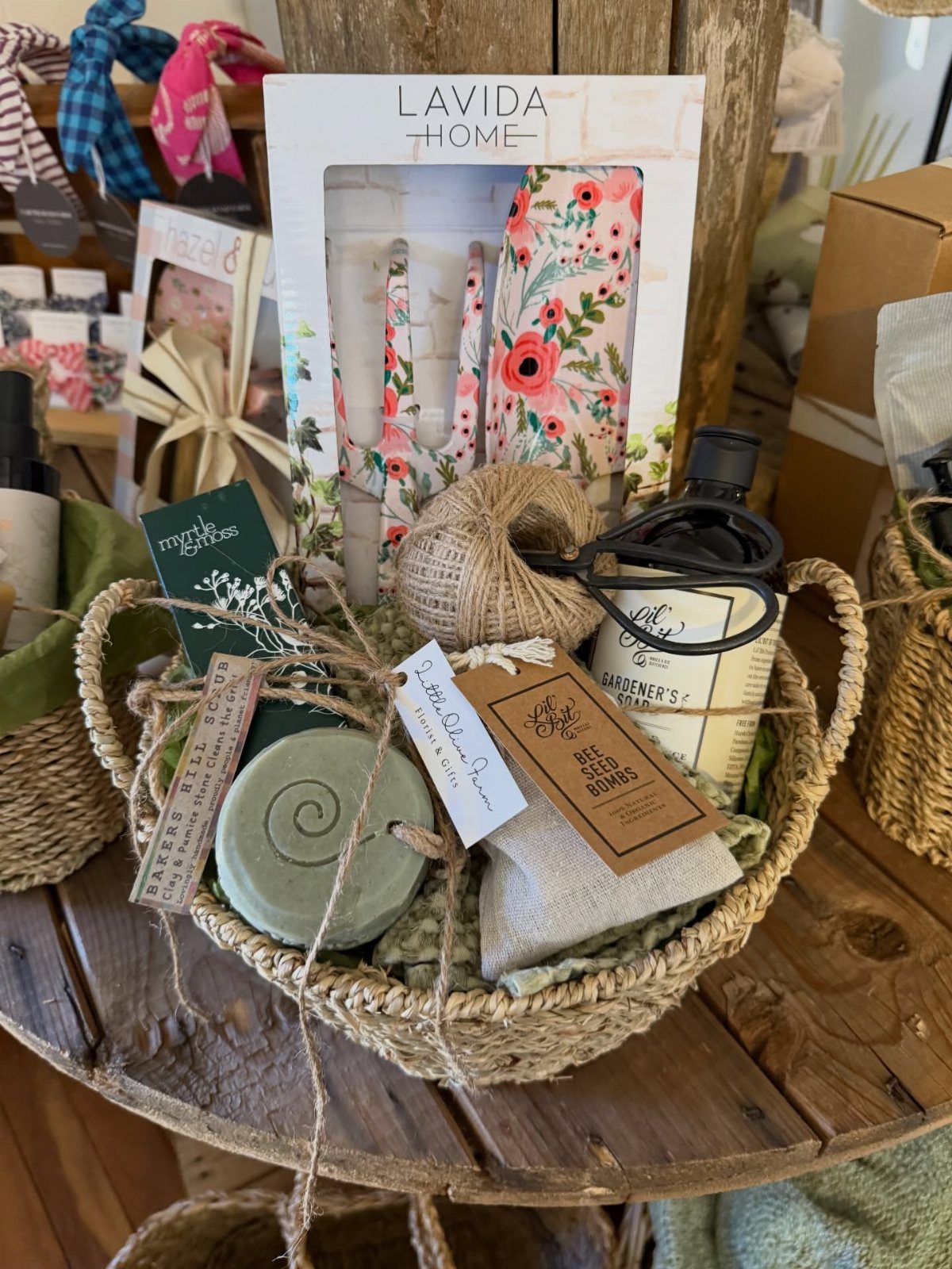 Woven gift basket with gardener's soap, seed bombs, and floral kitchen towels.