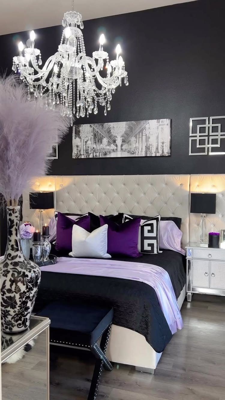 Luxurious bedroom with crystal chandelier, tufted headboard, and purple and black bedding.