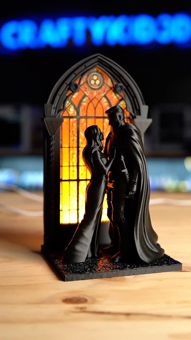 Miniature black couple embracing before a glowing gothic arched window diorama.