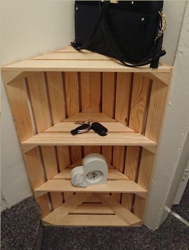 24 Corner Shelves IKEA Ideas for Kitchens, TVs and Plants 5 Triangular wooden corner shelf unit holding a black handbag, keys, and a white clock.