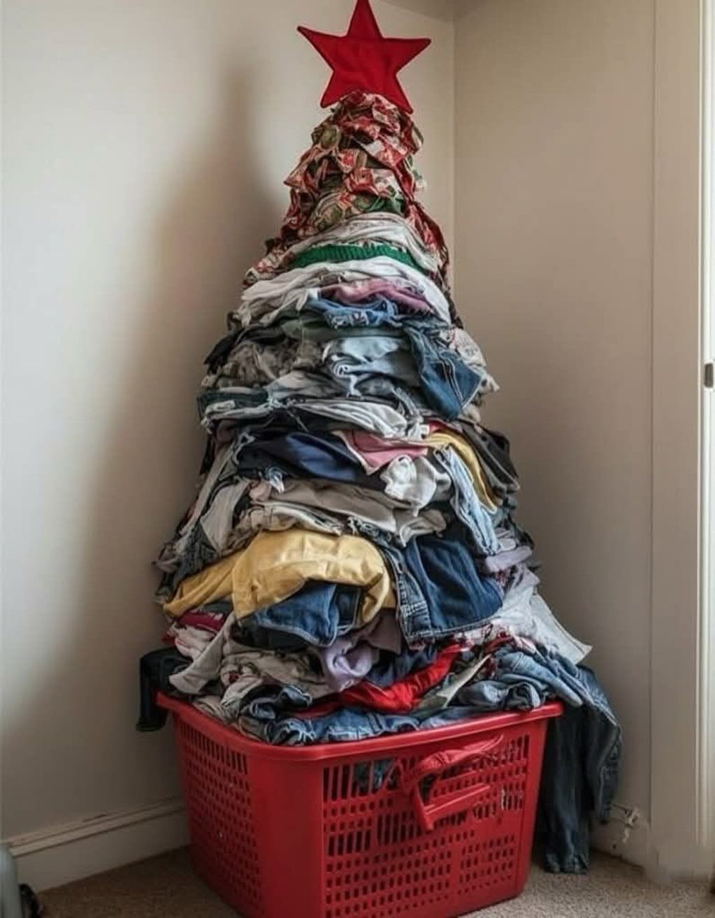 Laundry piled in a Christmas tree shape inside a red plastic basket with star.