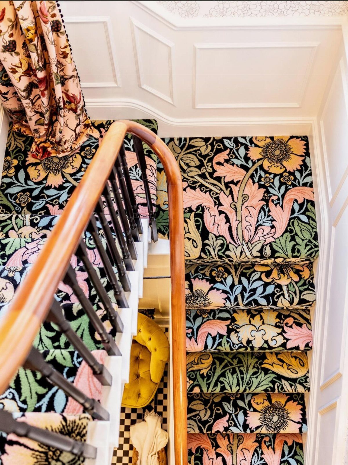 Stairs with Carpet: 23 Styles from Runners to Bold Patterns 11 Floral and leaf pattern carpet on a staircase with a wooden handrail.