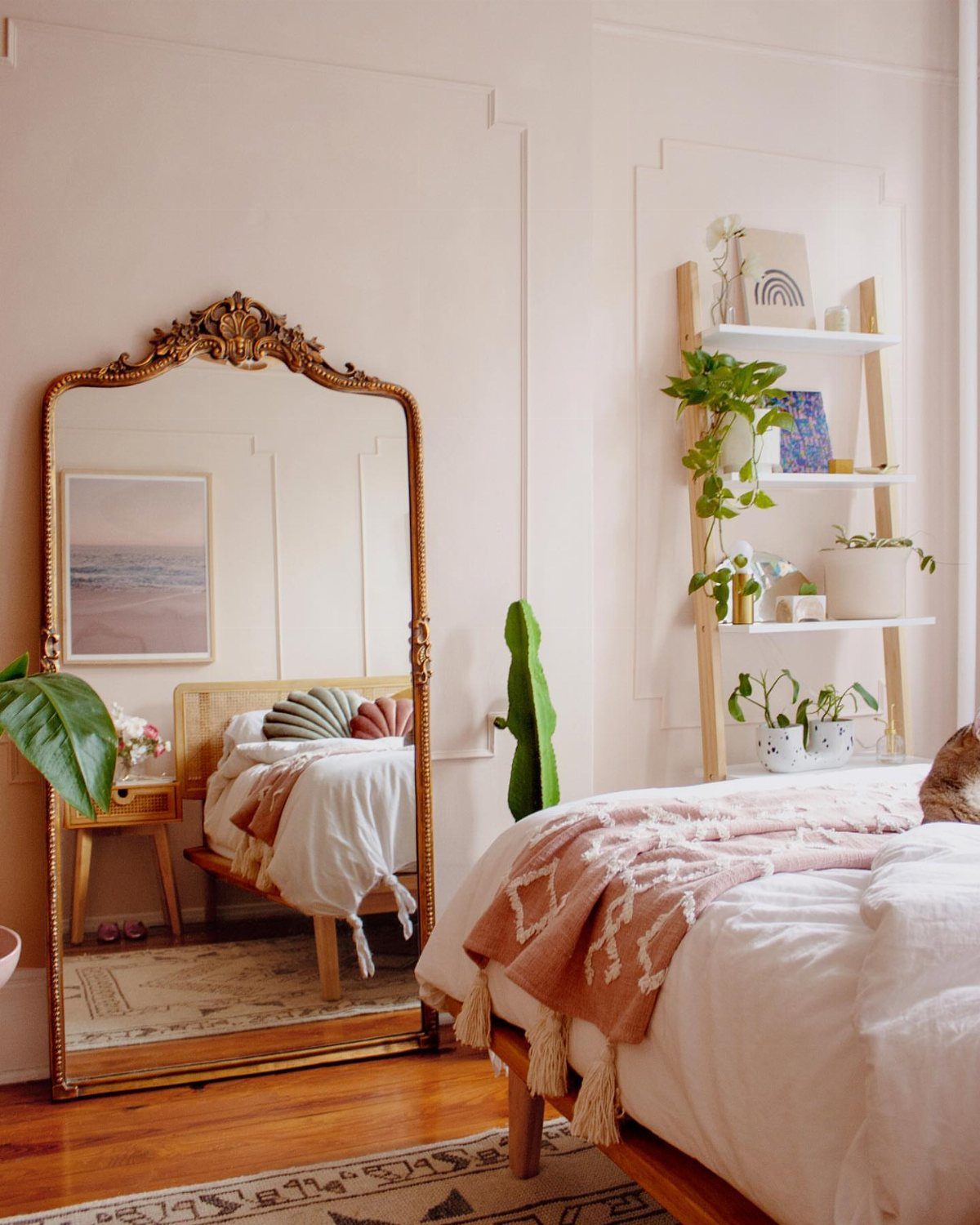 12 Small Bedroom Mirror Ideas That Make a Room Feel Bigger 12 Ornate gold floor mirror leaning against a pink wall in a bright bedroom