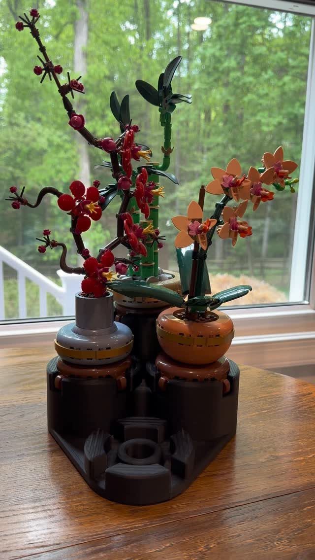 12 Artificial Flowers Decor Ideas, from Vases to Gift Boxes 3 LEGO botanical flowers including cherry blossoms and orchids on a wooden table.