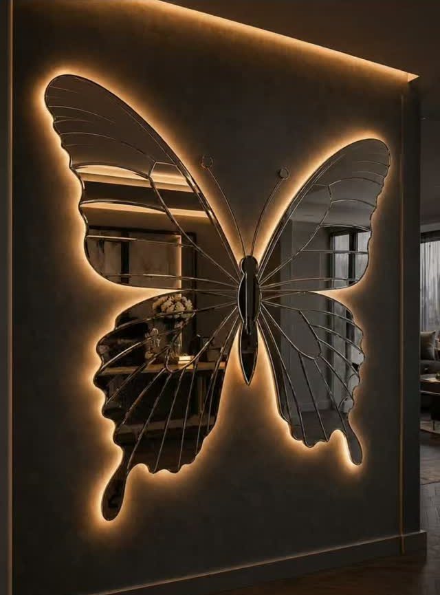 Mirror Wall Art: 25 Ideas from Sunburst to Floor Mirrors 16 Butterfly-shaped mirror with warm backlight glowing against a dark grey wall.