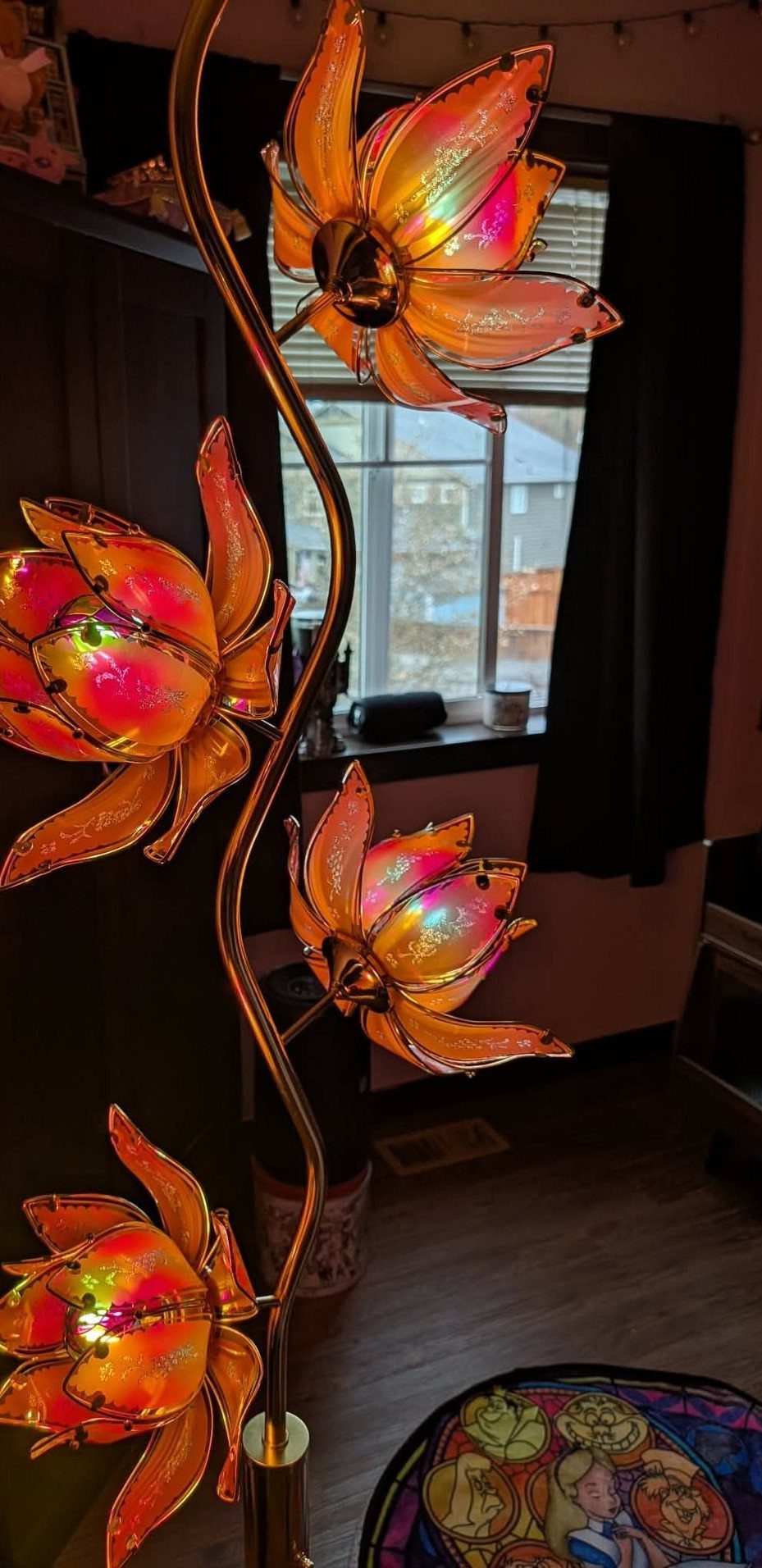Lotus floor lamp with four iridescent orange glass flowers on a curved gold stem.