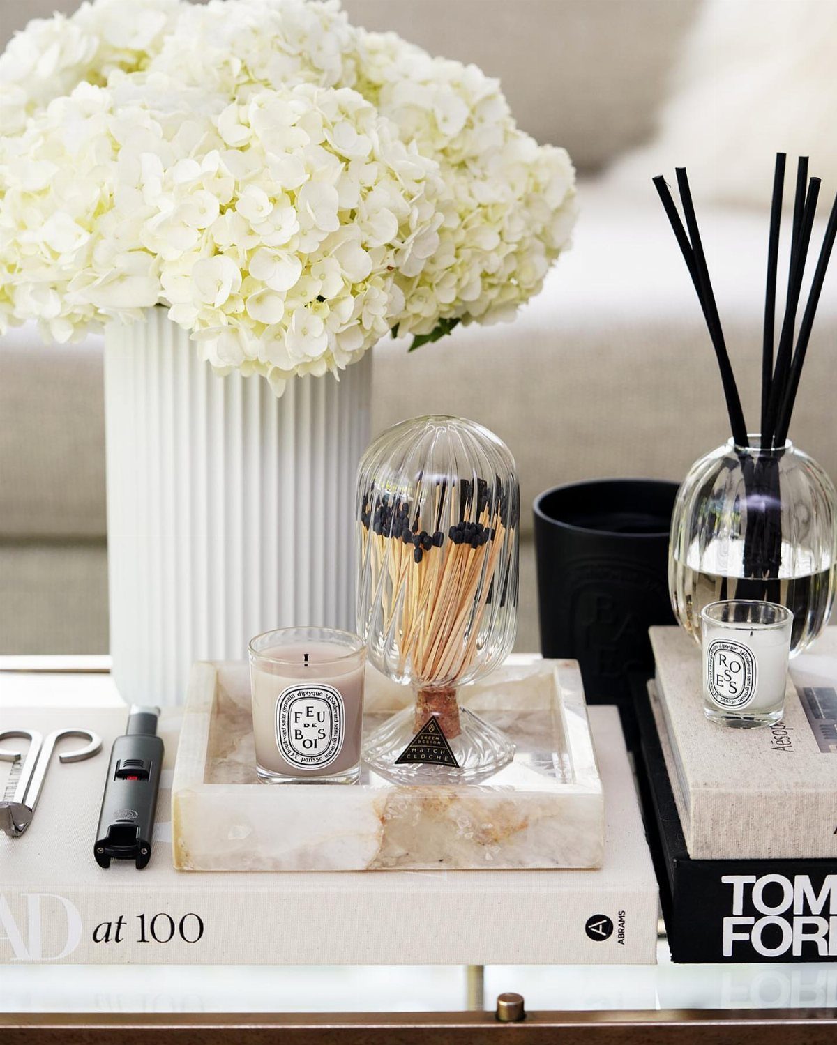 23 Cool House Items for Walls, Shelves, Desks, and Baths 14 Glass match cloche and candle on a marble tray beside white hydrangeas.