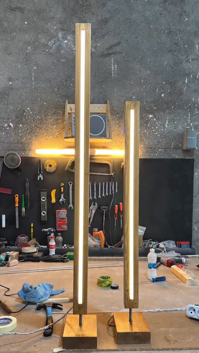 17 Handmade Lamps Ideas Using Wood, Concrete, and Glass Jars 7 Two minimalist wooden lamps with vertical LED strips in a workshop setting.