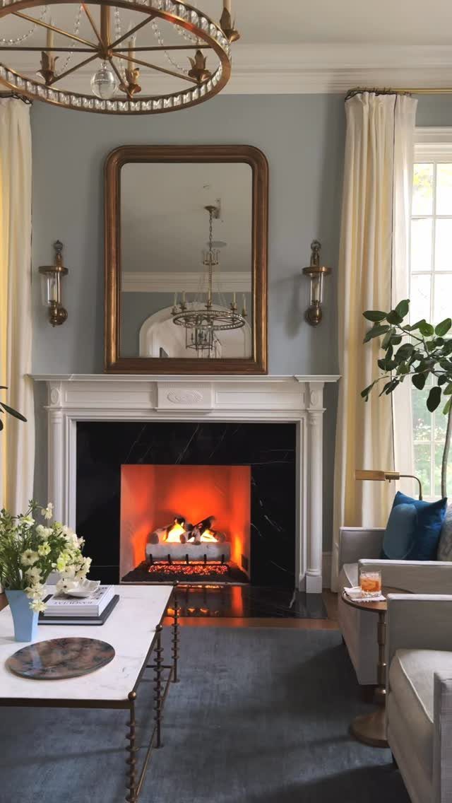 Mirror Wall Art: 25 Ideas from Sunburst to Floor Mirrors 21 Gold framed rounded mirror hanging above a white fireplace in a living room.