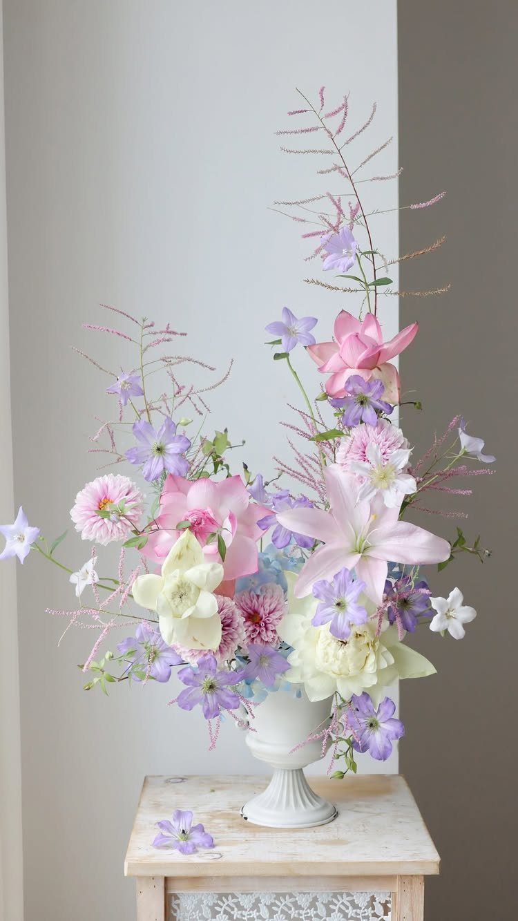 12 Artificial Flowers Decor Ideas, from Vases to Gift Boxes 7 Artificial flower arrangement in pink and purple tones inside a white pedestal vase.