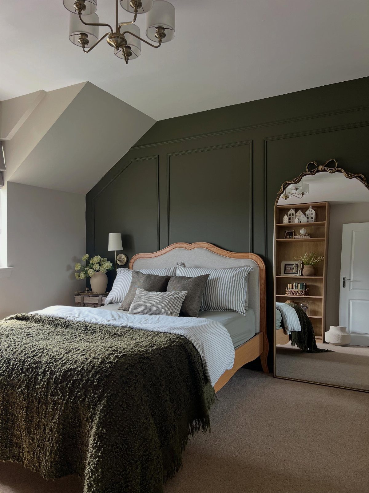 22 Bedroom Empty Wall Ideas, from Gallery Walls to Plaster 8 Dark green paneled feature wall behind a bed with a wooden headboard.