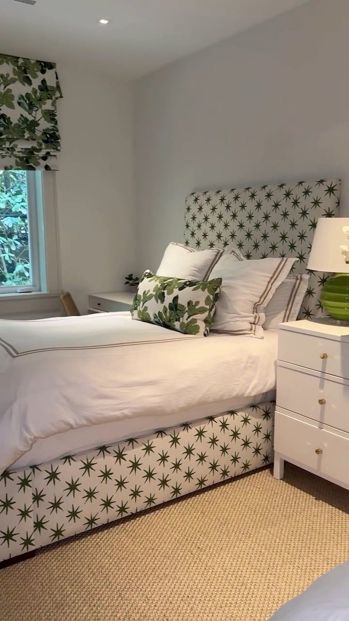 Bedroom with palm leaf patterned headboard, white bedding, and a woven tan rug.