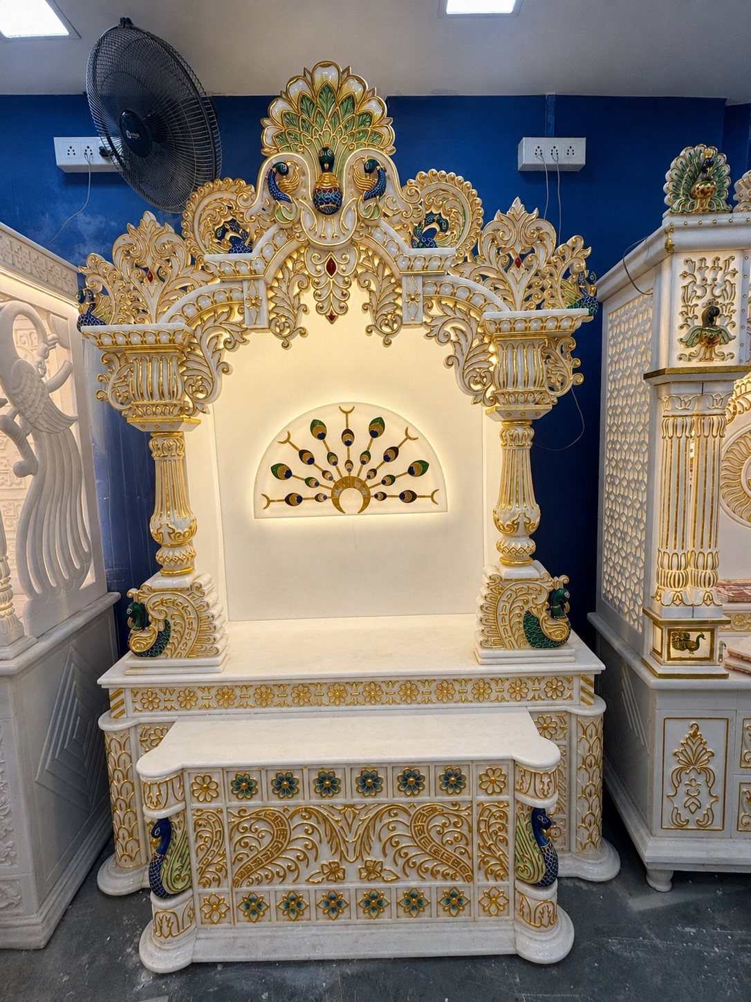 34 Puja Unit Design Modern Ideas for Your Home in 2026 34 Ornate white and gold marble pooja unit with a backlit decorative wall mural.
