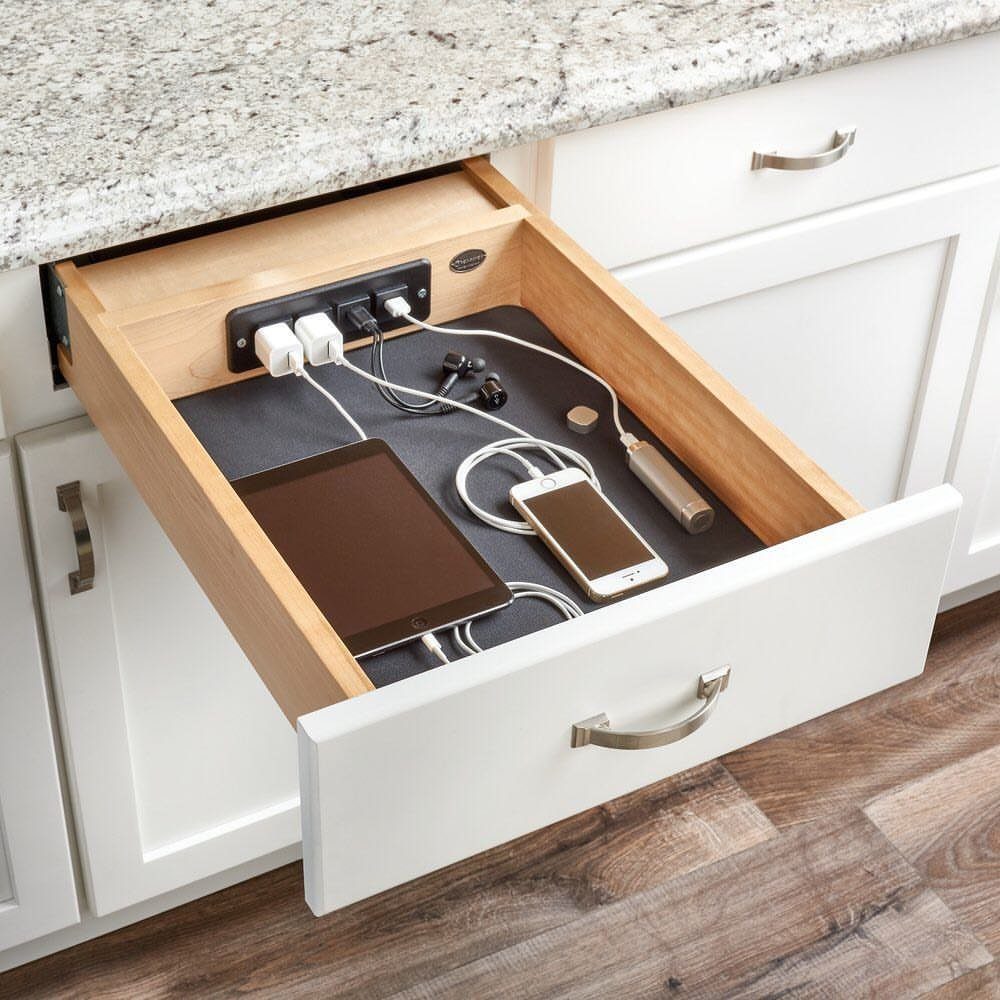 Charging station inside a white kitchen drawer with a tablet and smartphone.